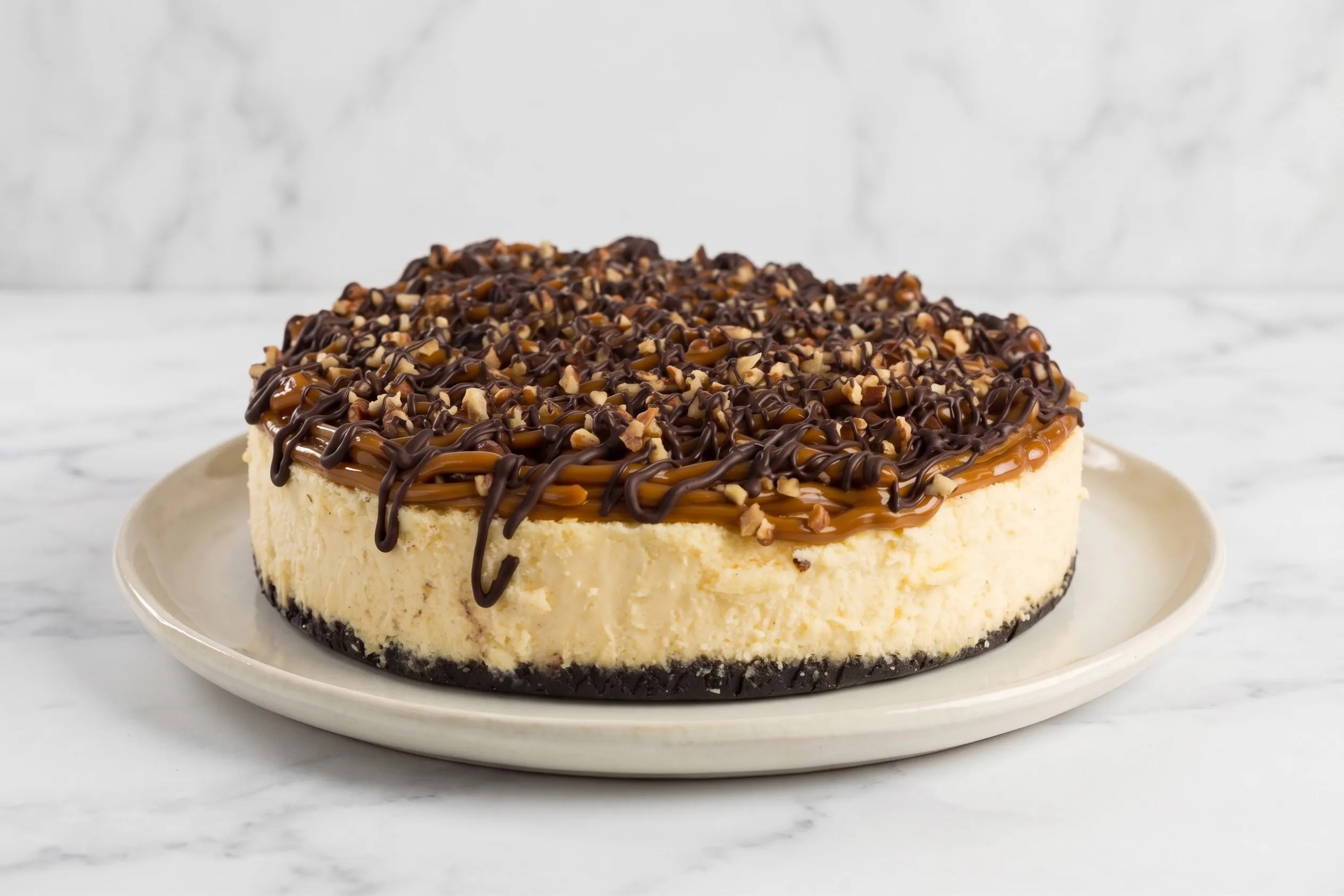 Cheesecake tortuga de DULUZ bañado en caramelo, chocolate y nuez tostada